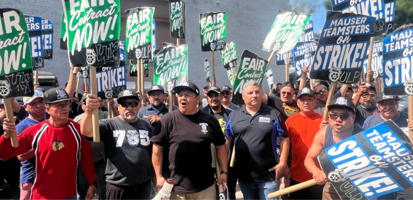 Workers hold signs reading "fair contract now" and "Mauser Teamsters on Strike"