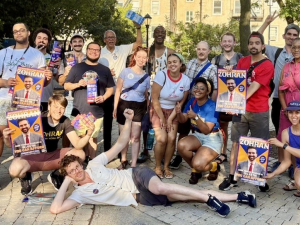 A group of around 30 canvassers pose with signs and fliers.