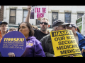 Several demonstrators gather with various signs about Medicaid and Social Security