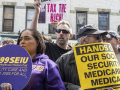 Several demonstrators gather with various signs about Medicaid and Social Security